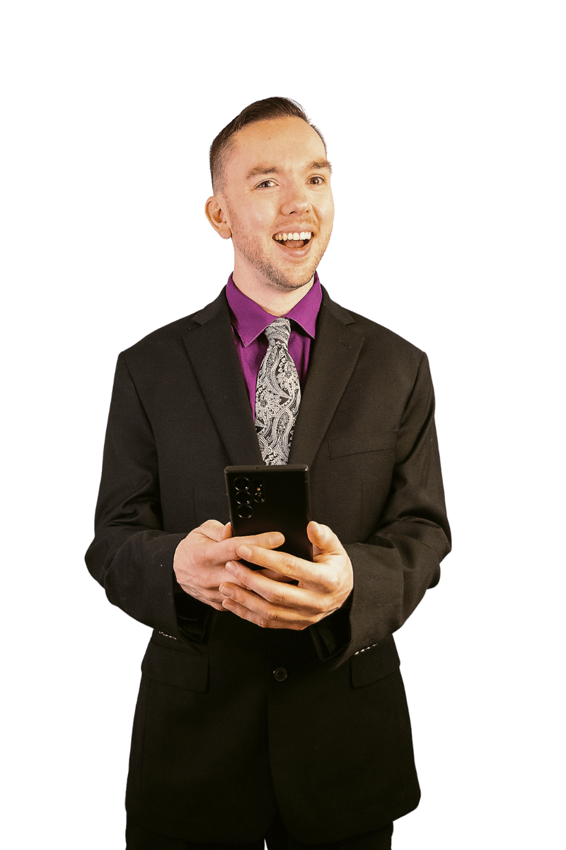 Jak Dawson in black suit with phone and smiling